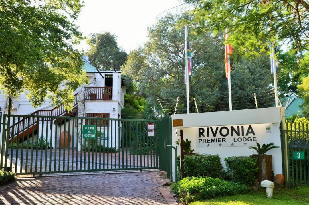 Welcoming lodge entrance with paved driveway and neatly trimmed garden hedges
