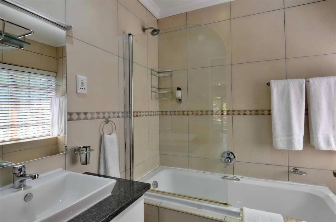 Spacious en-suite bathroom with sleek fixtures and soft lighting