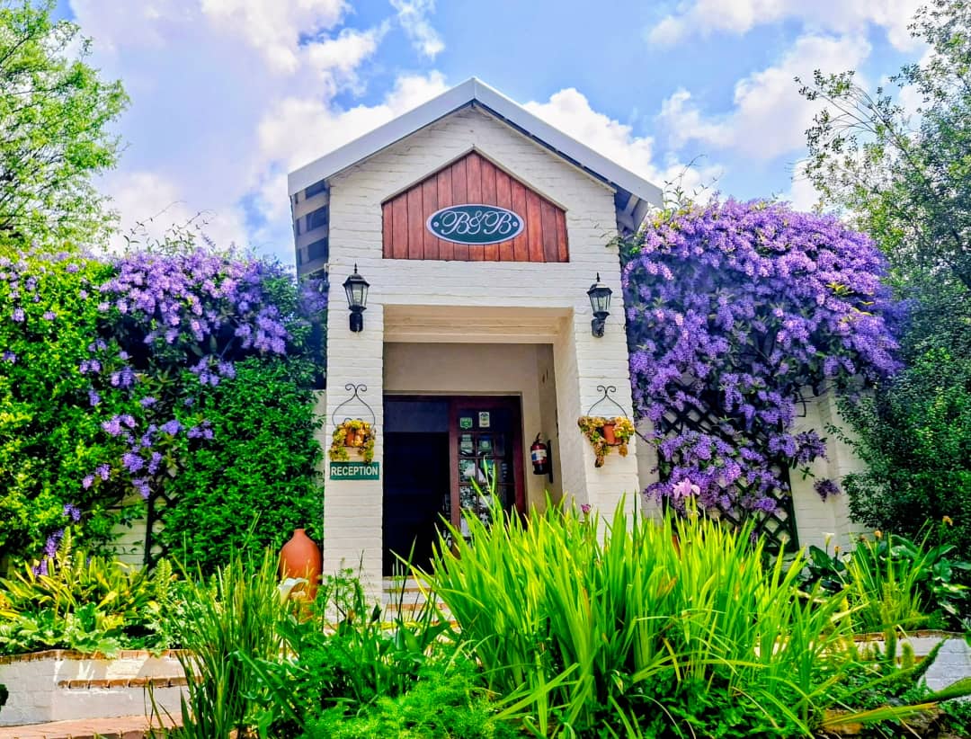 Front entrance with driveway, signage and manicured garden borders