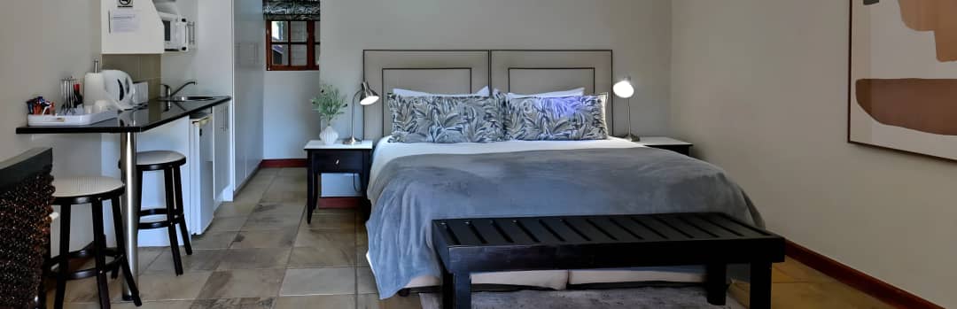 Crisp white bedding and warm lighting in a spacious en-suite room