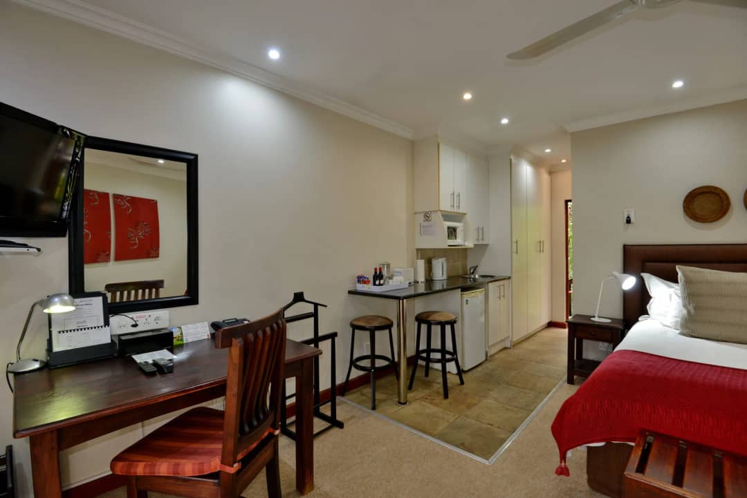 Self-catering room with a desk, kitchenette and double bed
