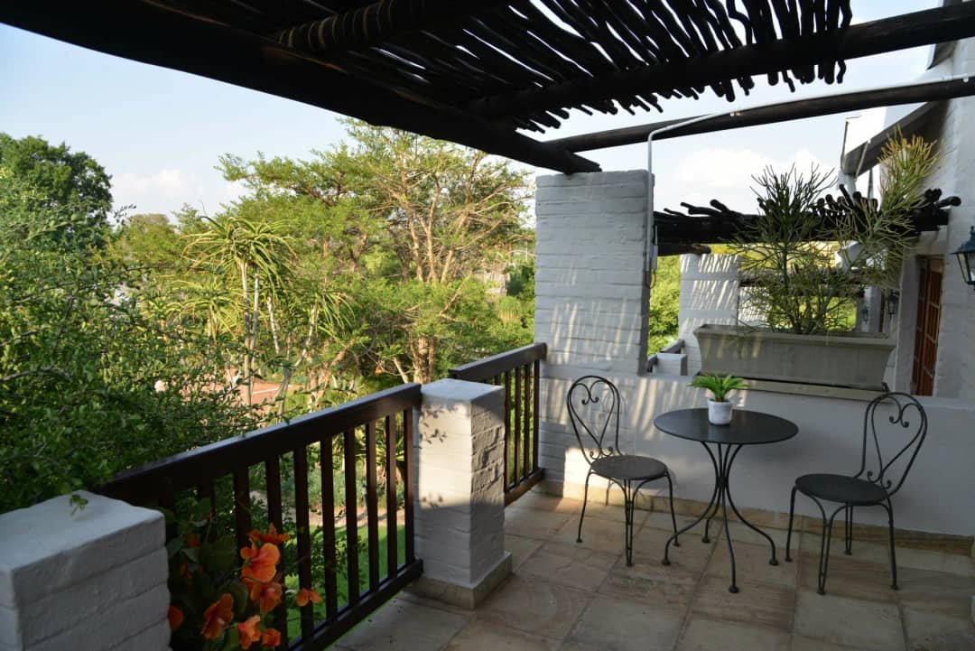 Private balcony with a small table and two chairs among the trees
