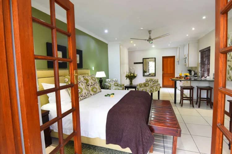 Spacious room with a double bed, ceiling fan and dining nook