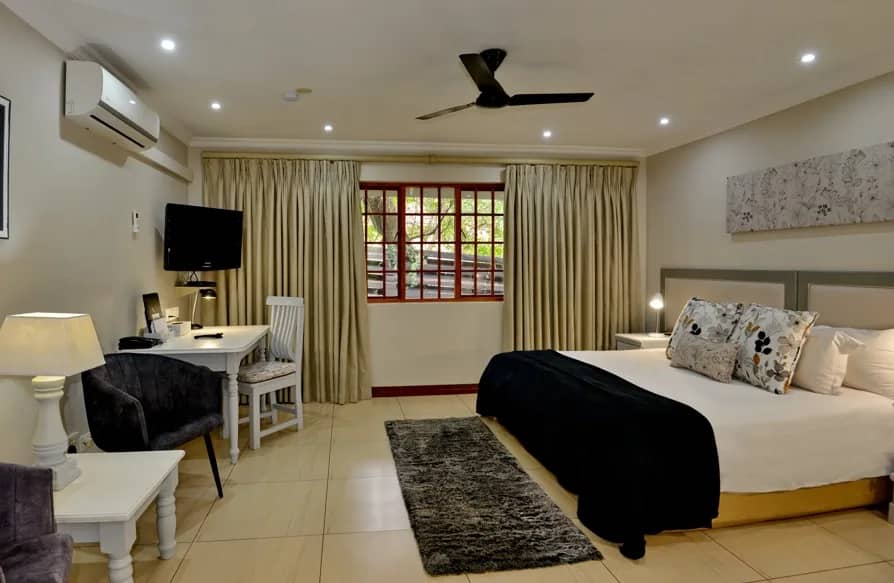 Bedroom with a king bed, desk, air-conditioning and ceiling fan