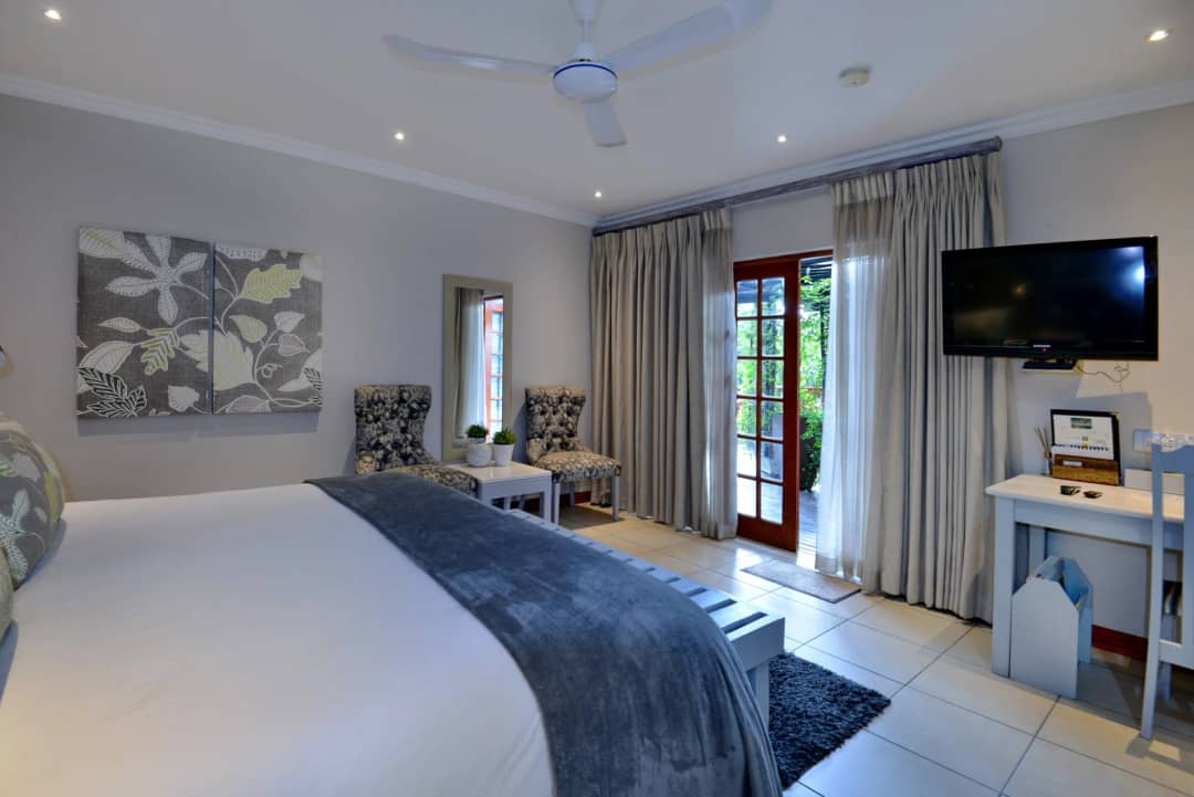 Bright bedroom with a TV and French doors to the garden