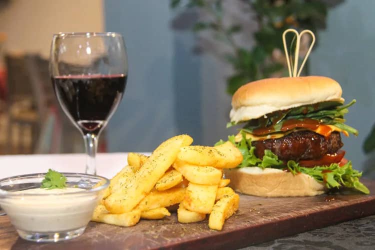 Burger and chips with a glass of red wine