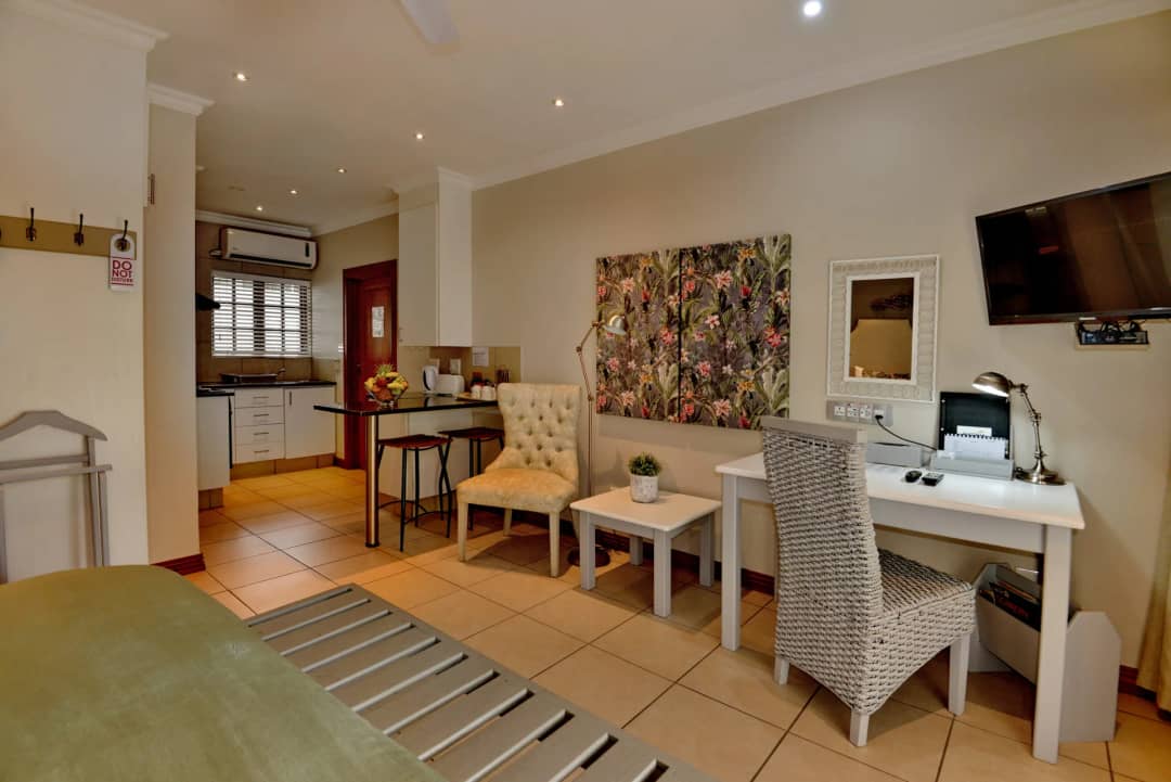 Room with a desk, two chairs and a kitchenette